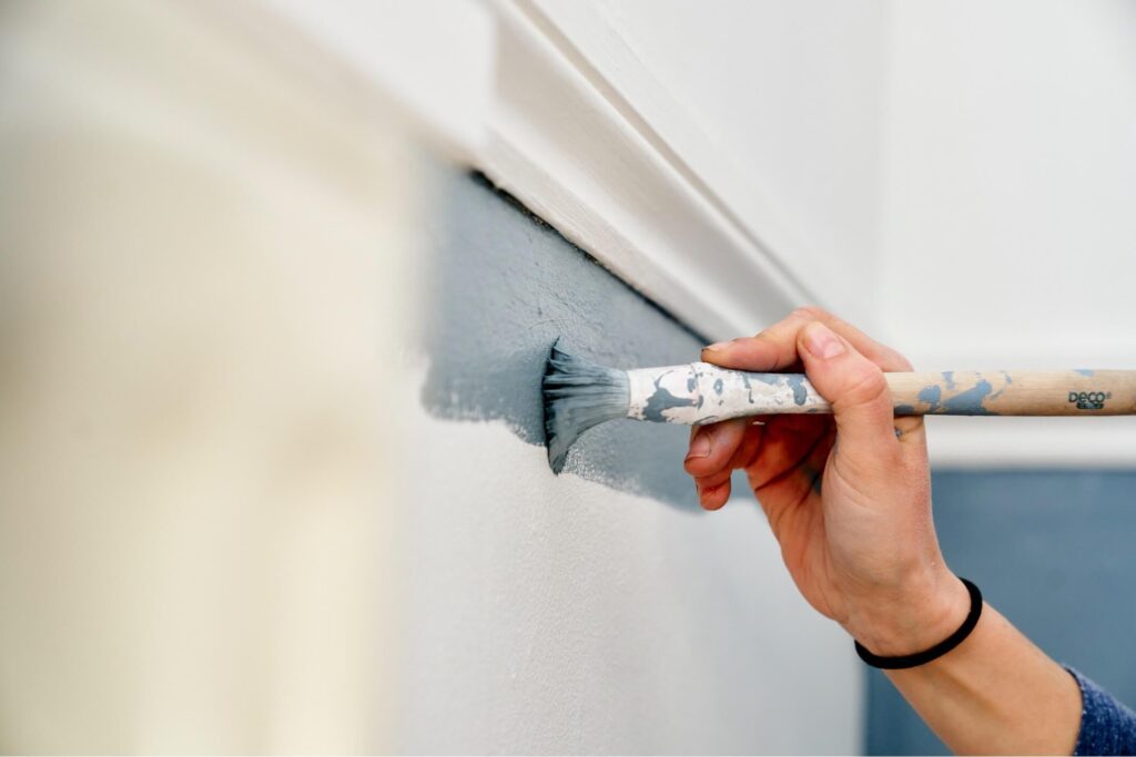 close-up-of-hand-using-paintbrush-to-paint-wall-2022-03-04-02-41-51-utc-1024x683